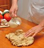 Pouring milk on pizza dough
